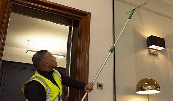 Traditional window cleaning - removing soapy water with a squeegee