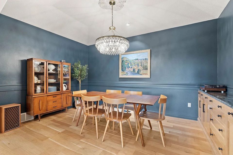 A dining room with a table and chairs and a chandelier.