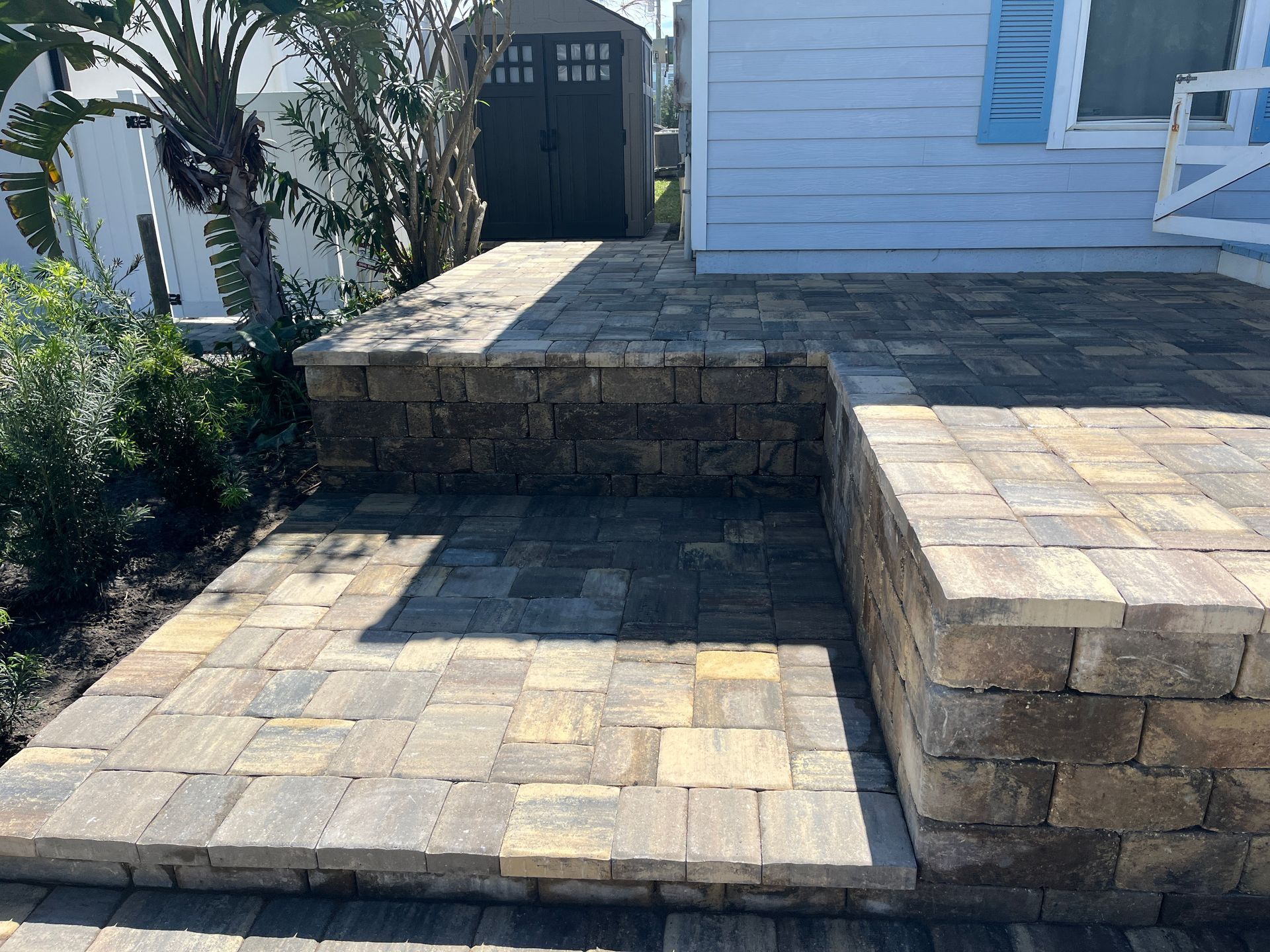 A paver walkway with steps leading up to a house.