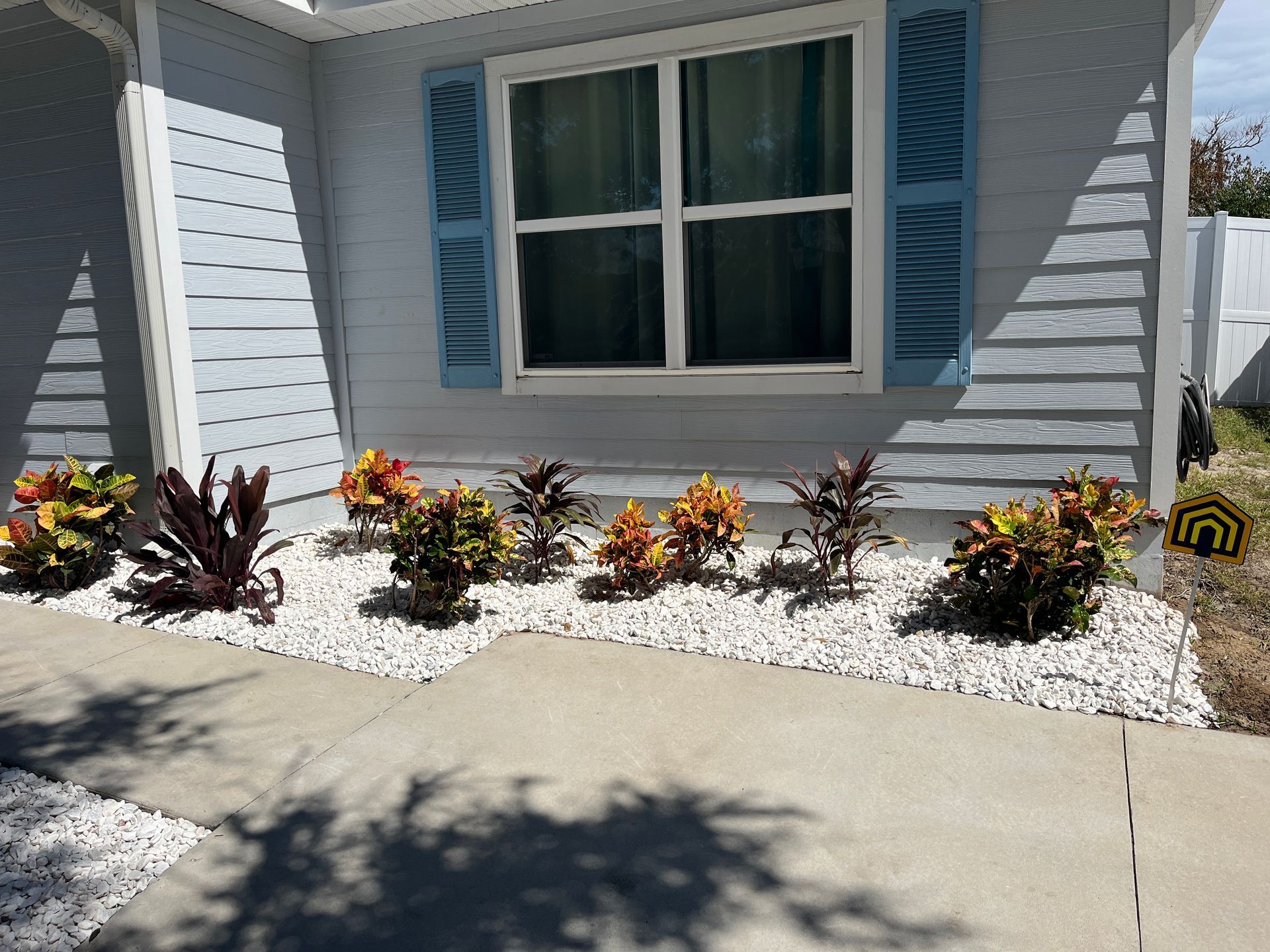 A house with blue shutters and a garden in front of it