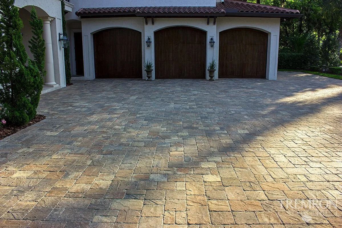 A driveway in front of a house with three garage doors