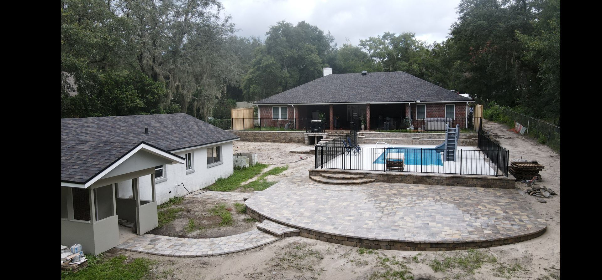 An aerial view of a house with a pool in the backyard.