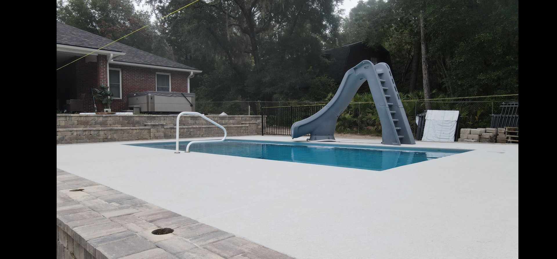 A large swimming pool with a slide in the middle of it.