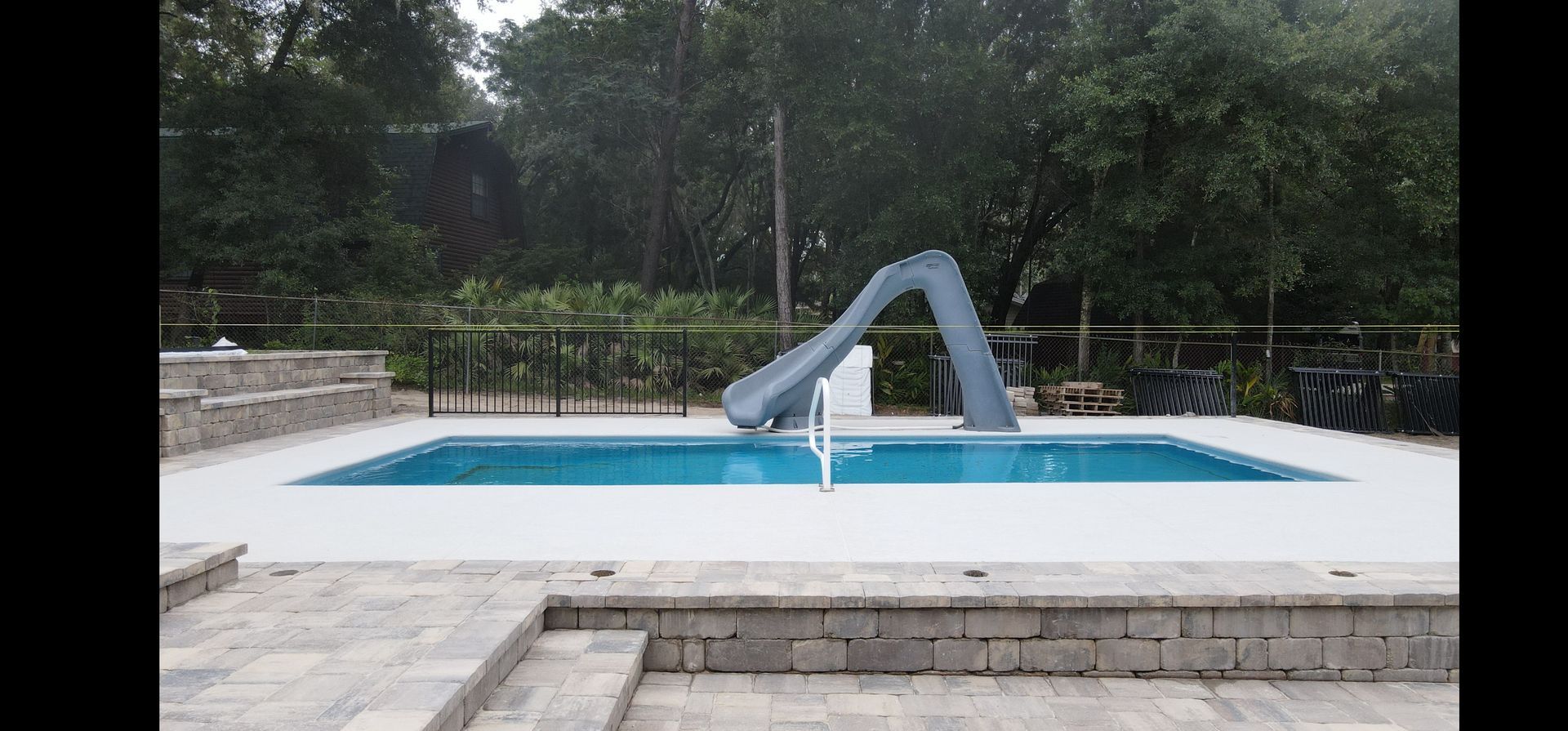 A large swimming pool with a slide in the middle of it.