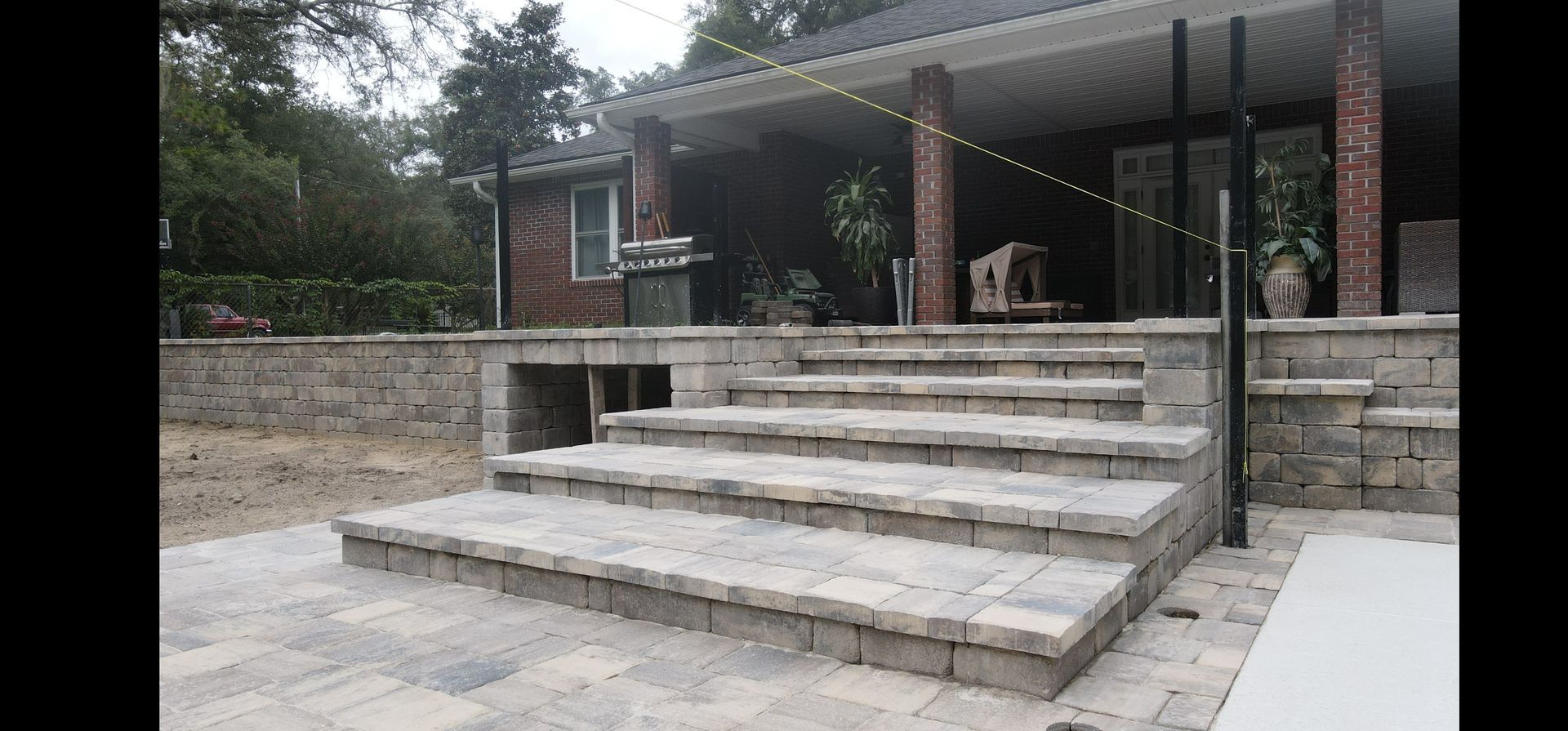 A set of paver stairs leading up to a porch of a house.