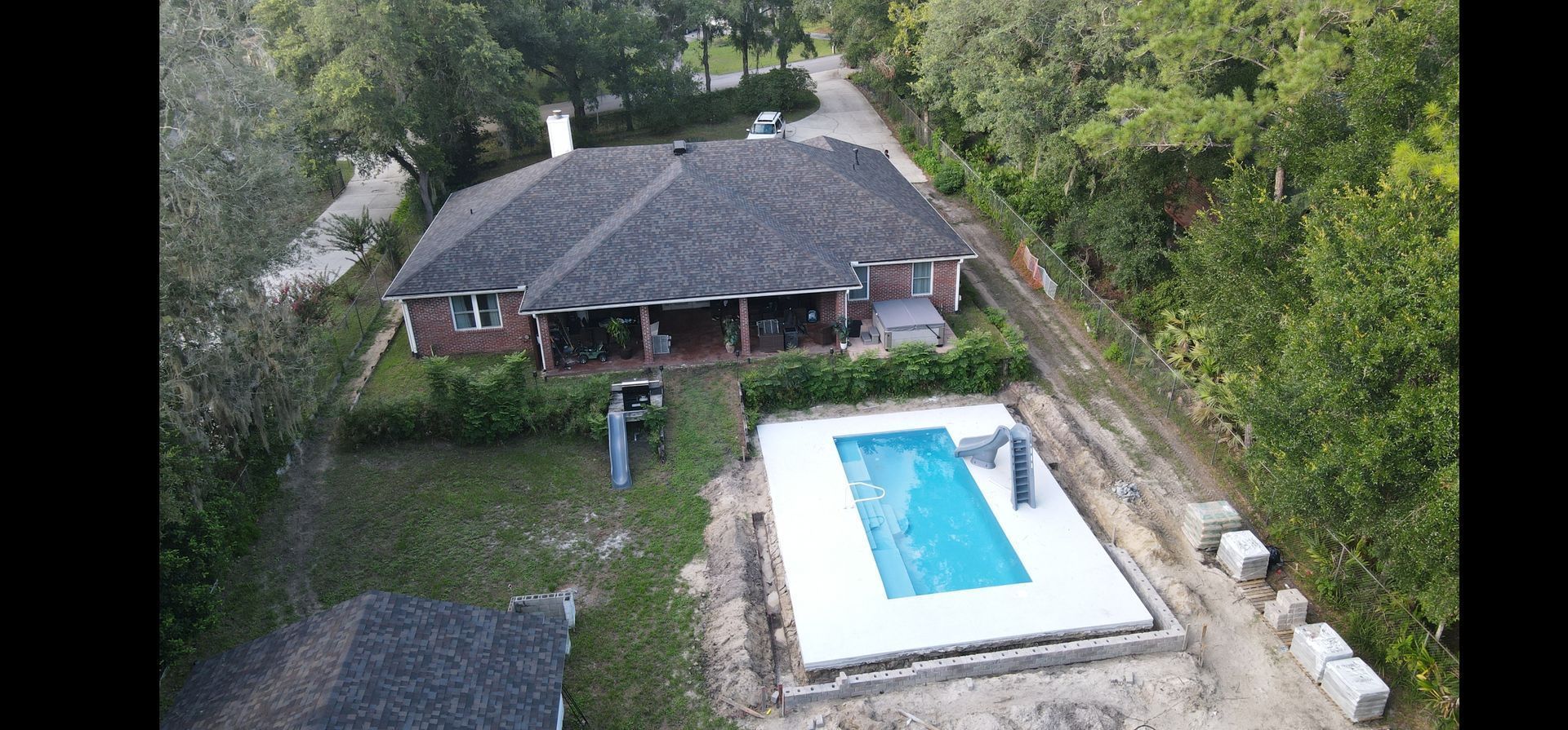 An aerial view of a house with a pool in the backyard.