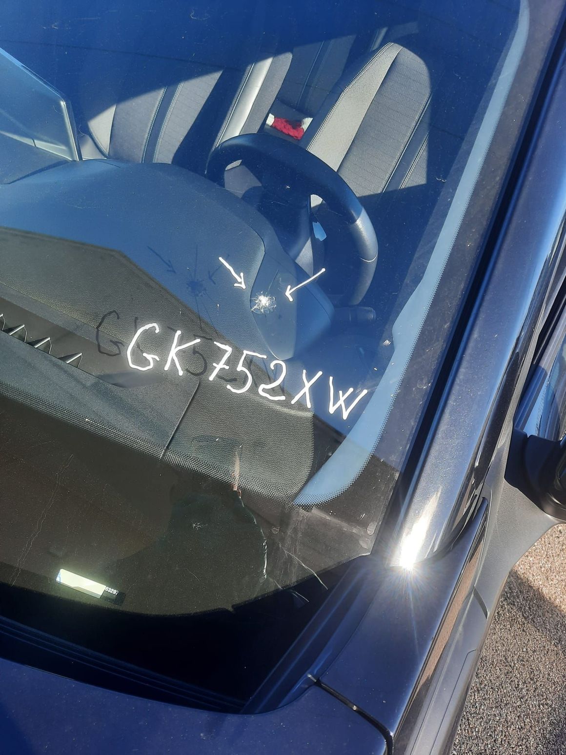 Primo piano delle sospensioni anteriori metalliche, delle ruote e dei componenti della trasmissione di un'auto su uno sfondo bianco pulito.