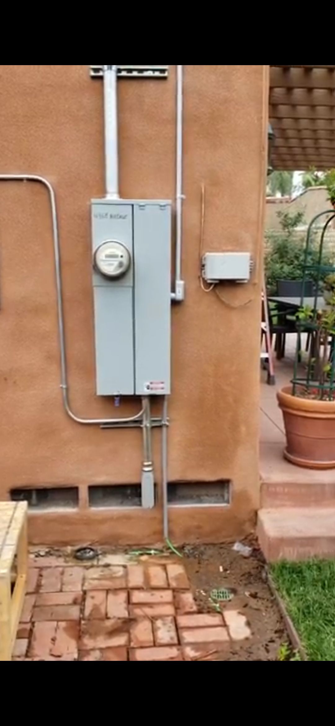 There is a meter on the side of a building.