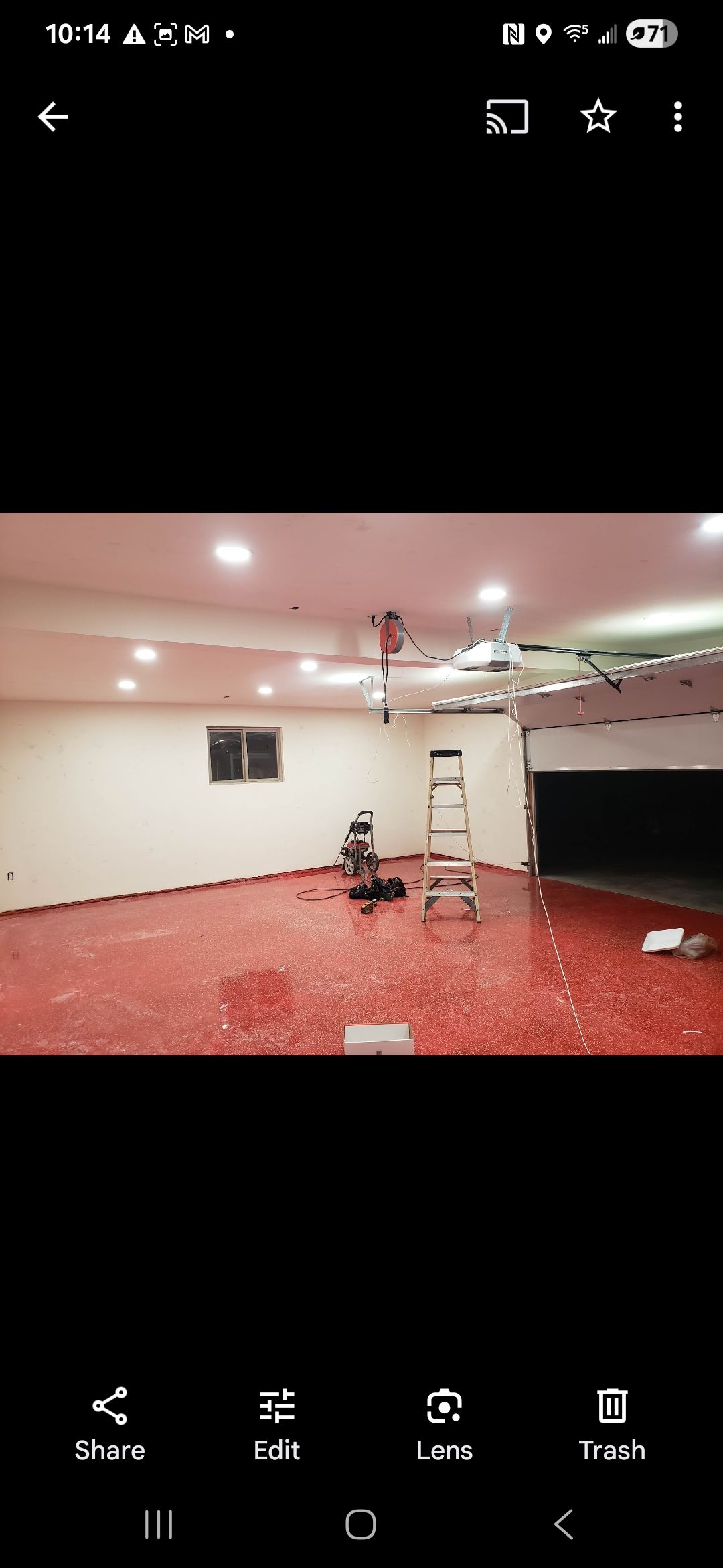 A picture of a garage with a ladder hanging from the ceiling.