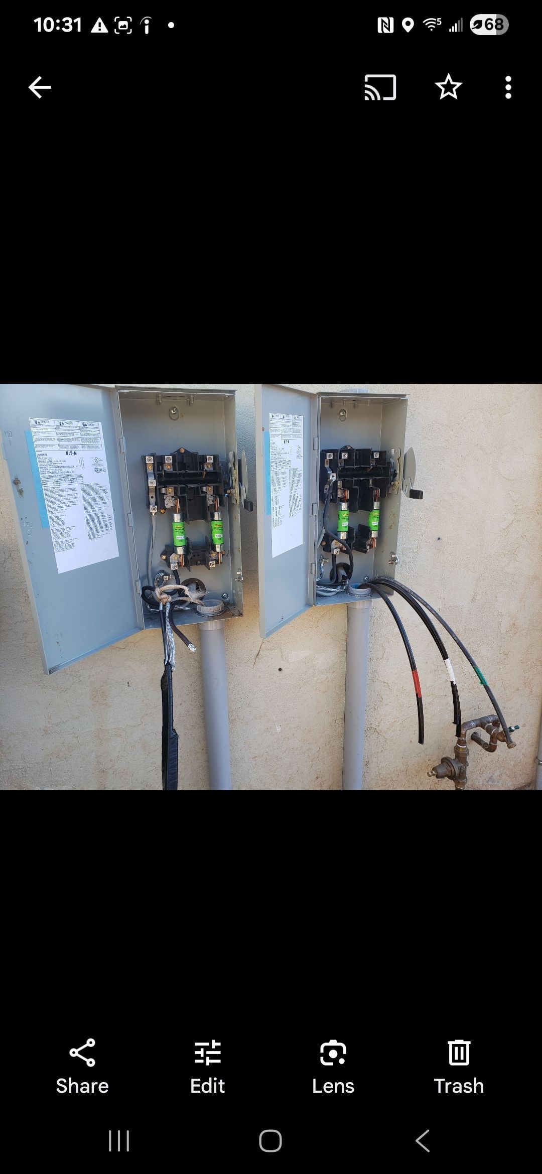 Two electrical boxes are sitting next to each other on a wall.