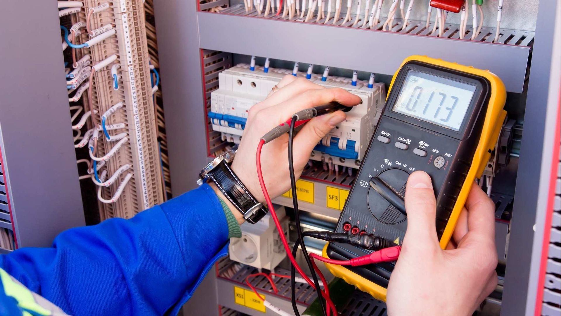 A person is using a multimeter to test a circuit board.
