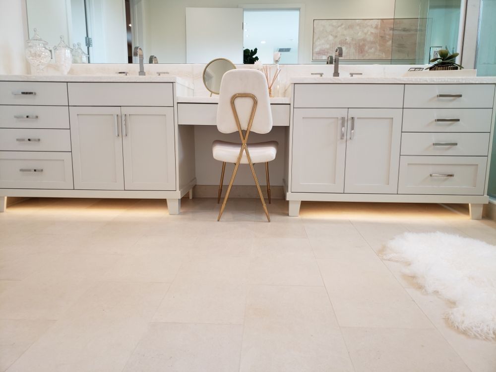 A bathroom with two sinks , a vanity , a chair and a mirror.