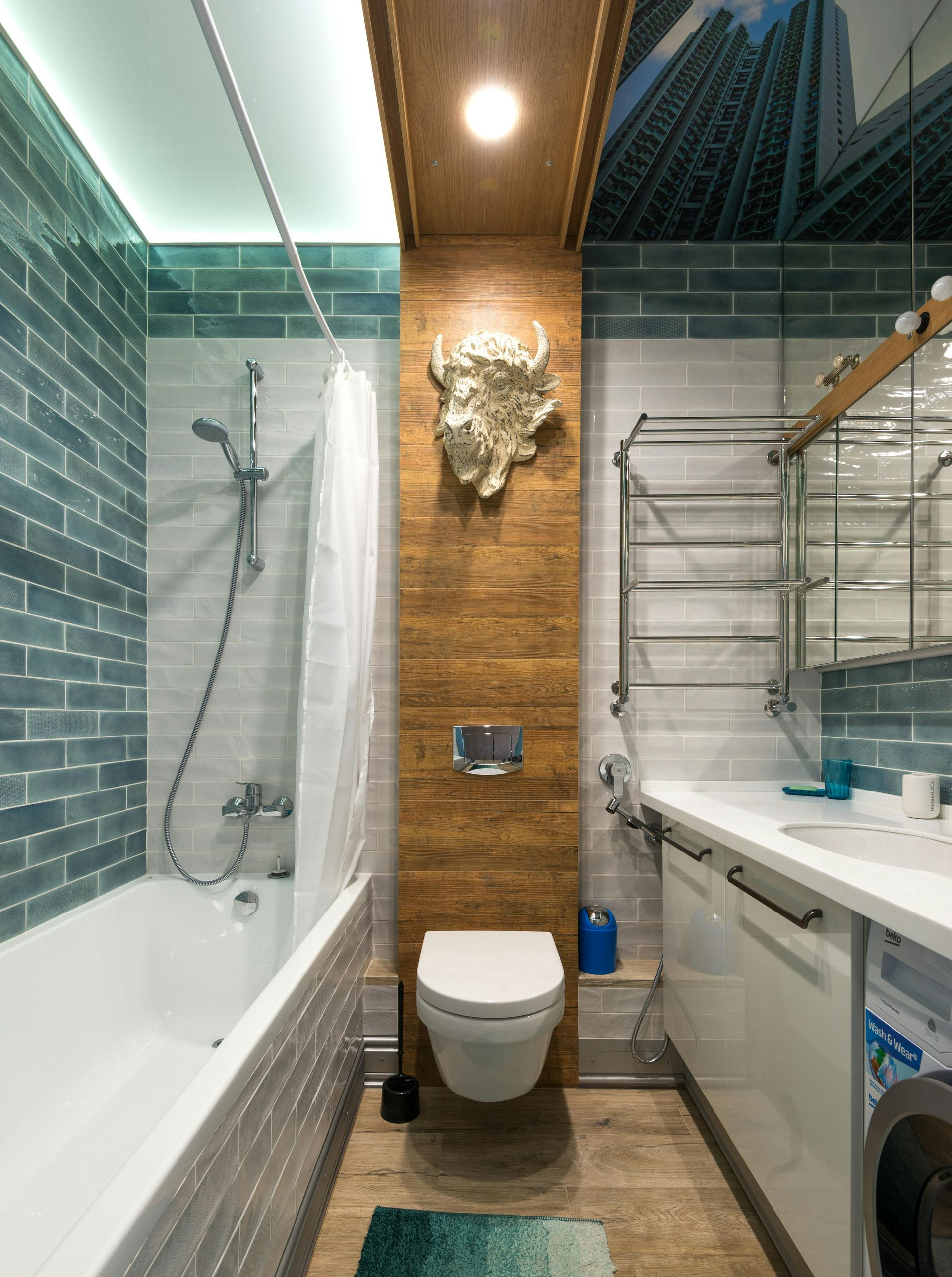 Bathroom with blue brick wall, bathtub, toilet, and wood accent.