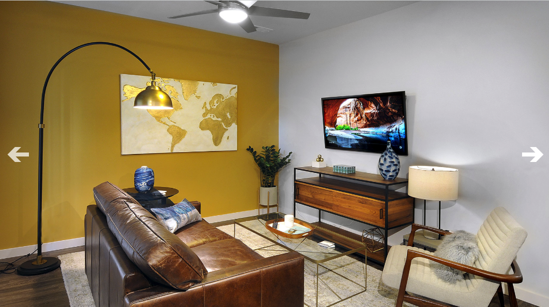 A living room with a couch , chair , table and television.