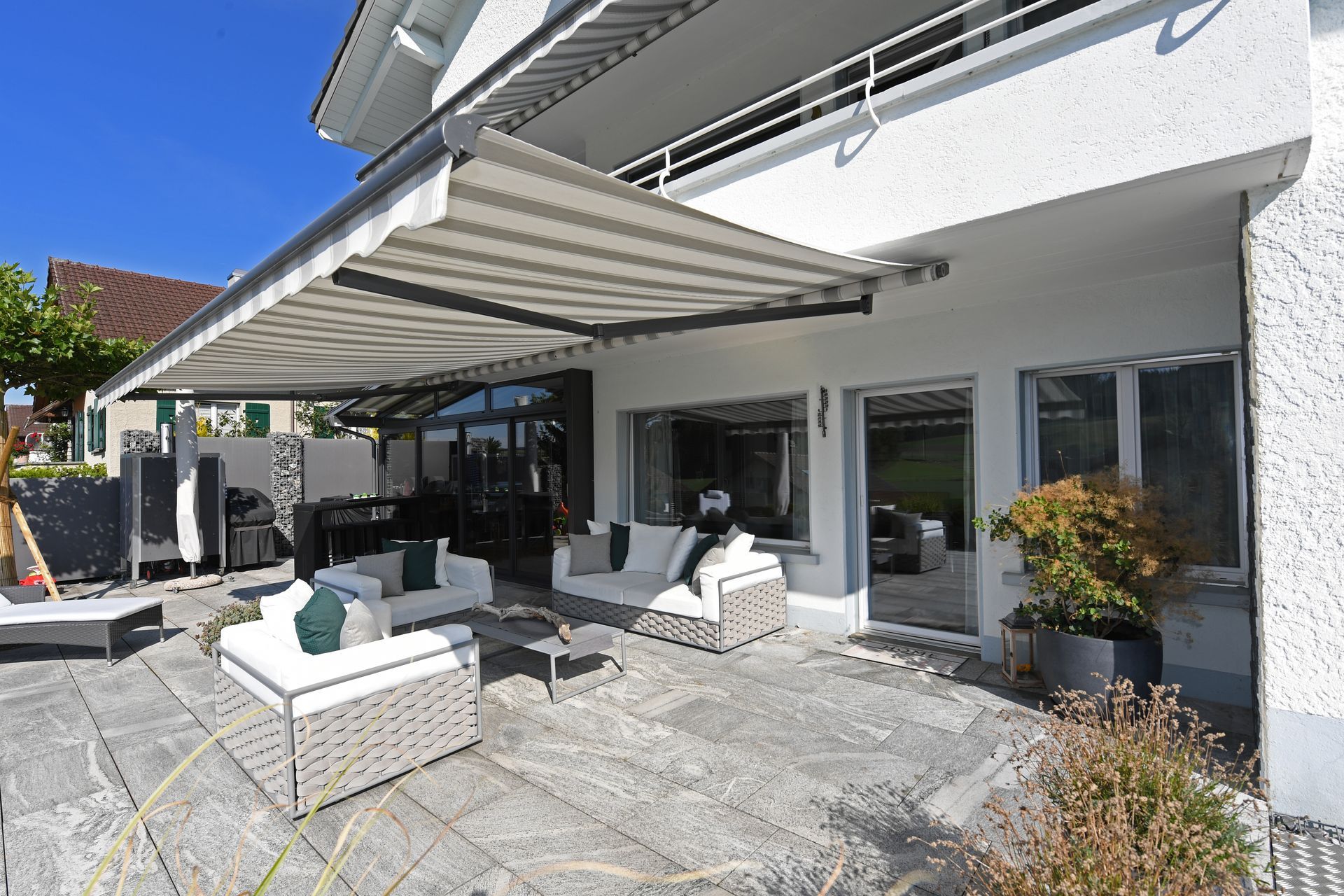 Ein großes weißes Haus mit einer überdachten Terrasse.