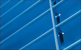 Eine Nahaufnahme einer blauen Jalousie, an der ein Seil hängt.