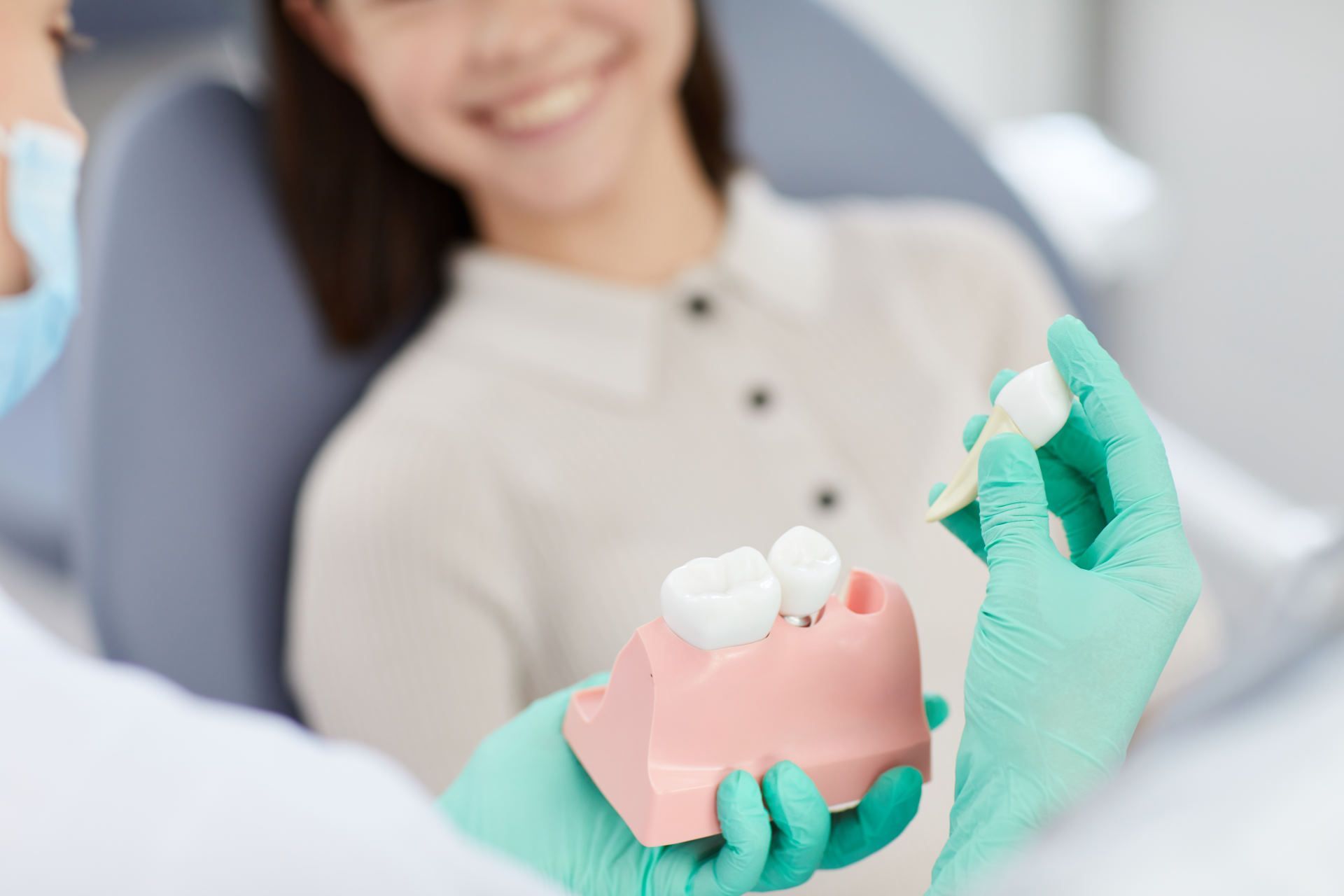person holding a model of teeth to show the removal of a wisdom tooth