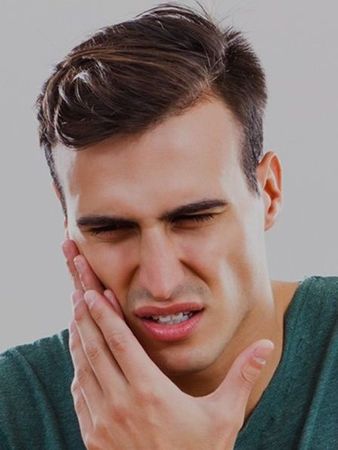 guy in pain holding his face for emergency care