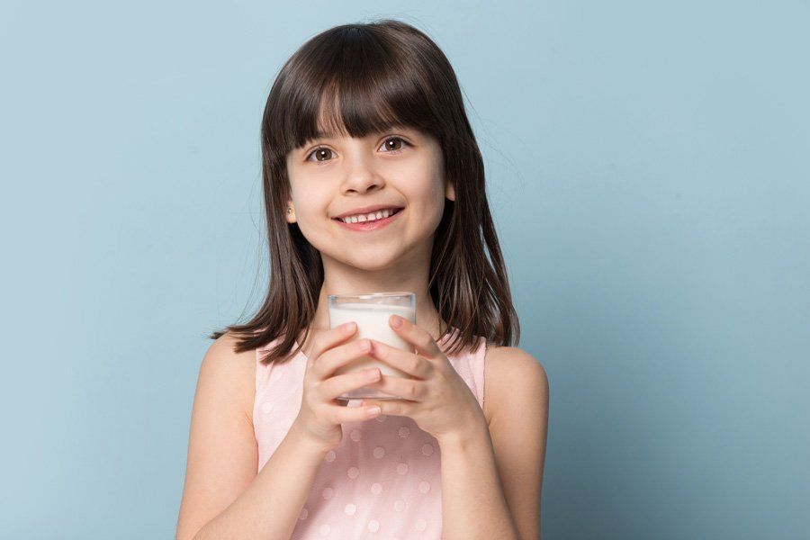 Girl Holding a Glass of Milk — Eastpointe, MI — Eastland & Professional Dental Center