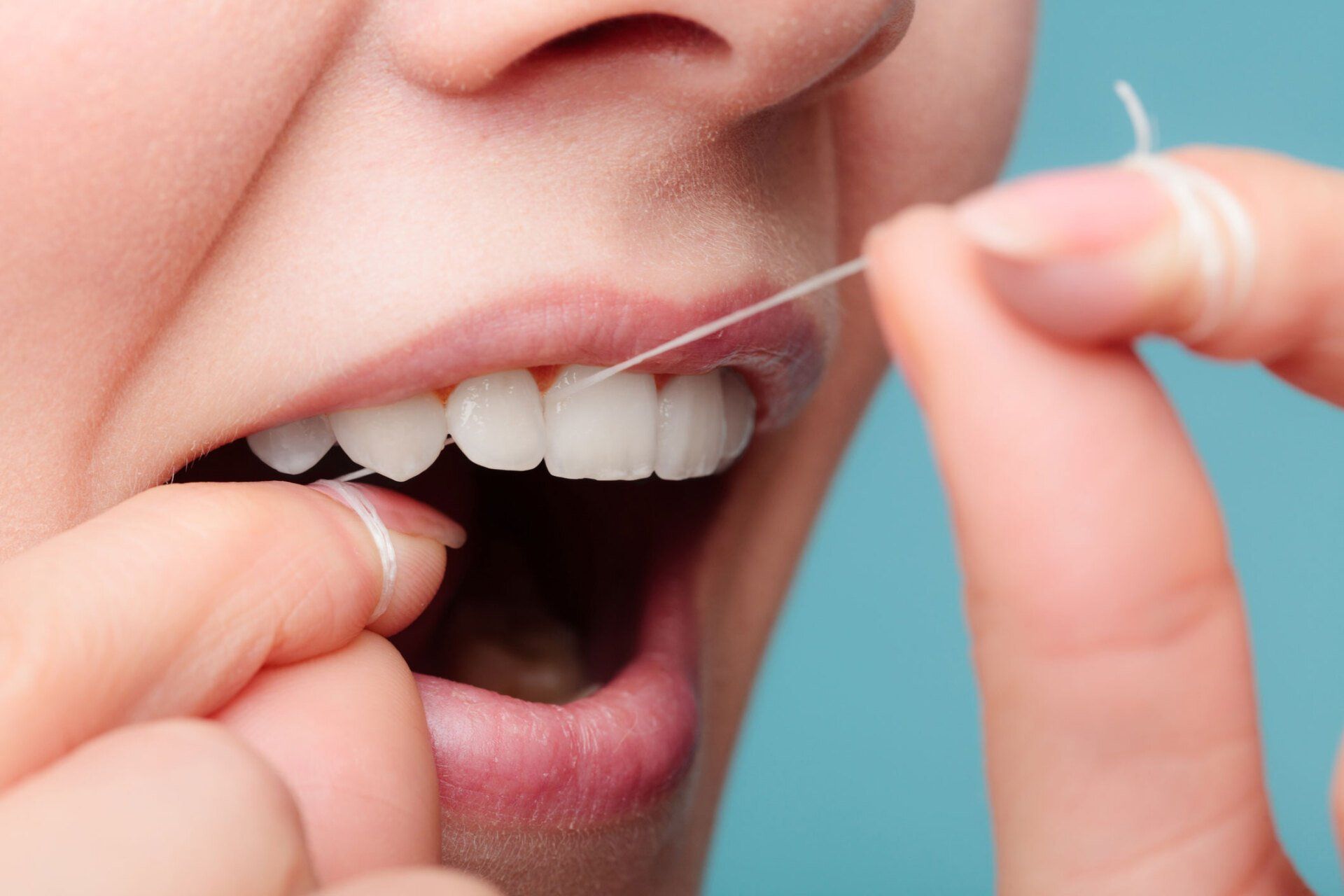 Woman Using Dental Floss — Eastpointe, MI — Universal Dental Center