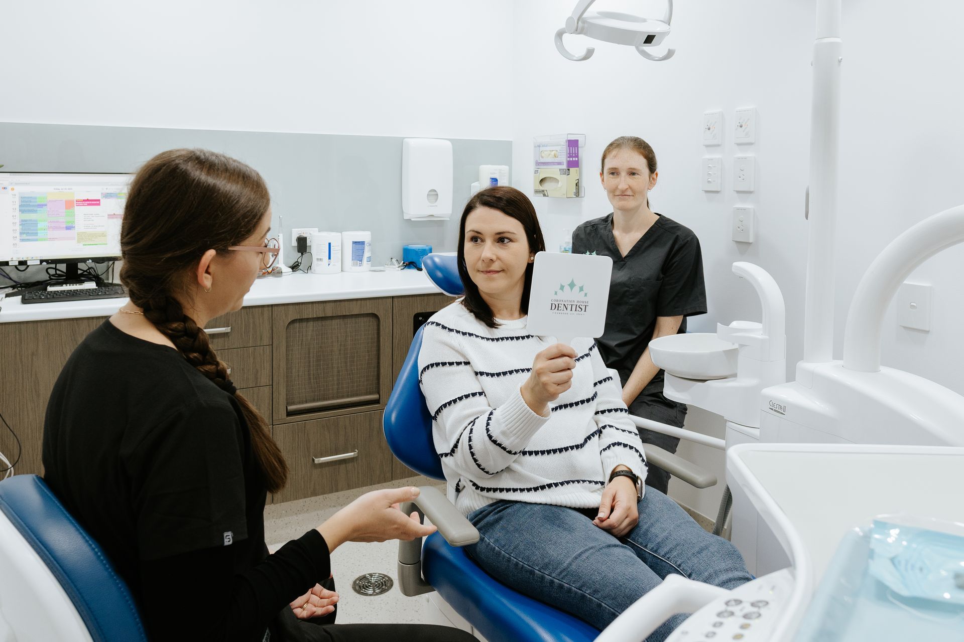 A Dentist is Holding a Model of Teeth While Talking to a Patient — Coronation House Dentist in Nambour, QLD