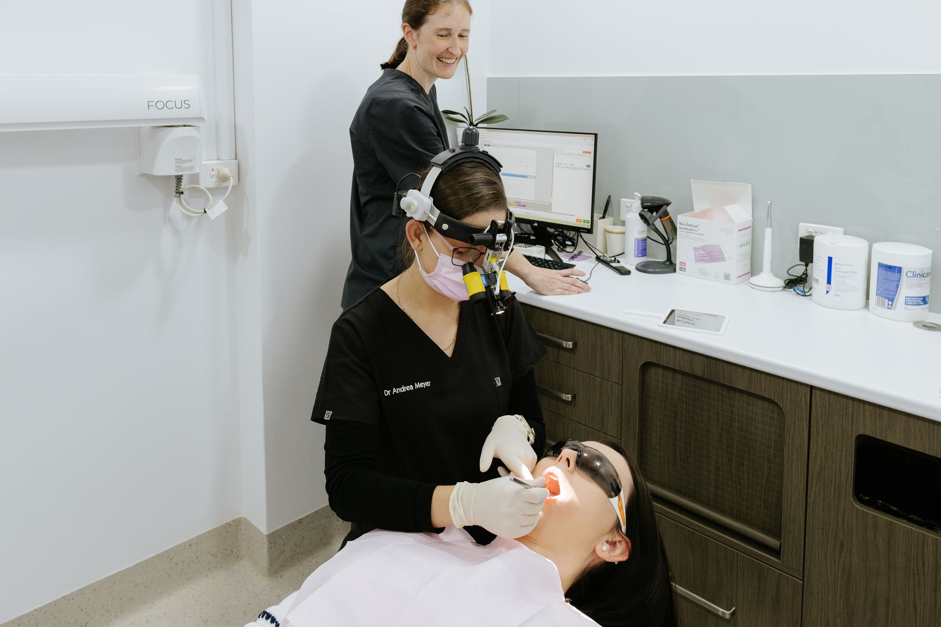 A Woman is Examining a Man 's Teeth in a Dental Office — Coronation House Dentist in Nambour, QLD