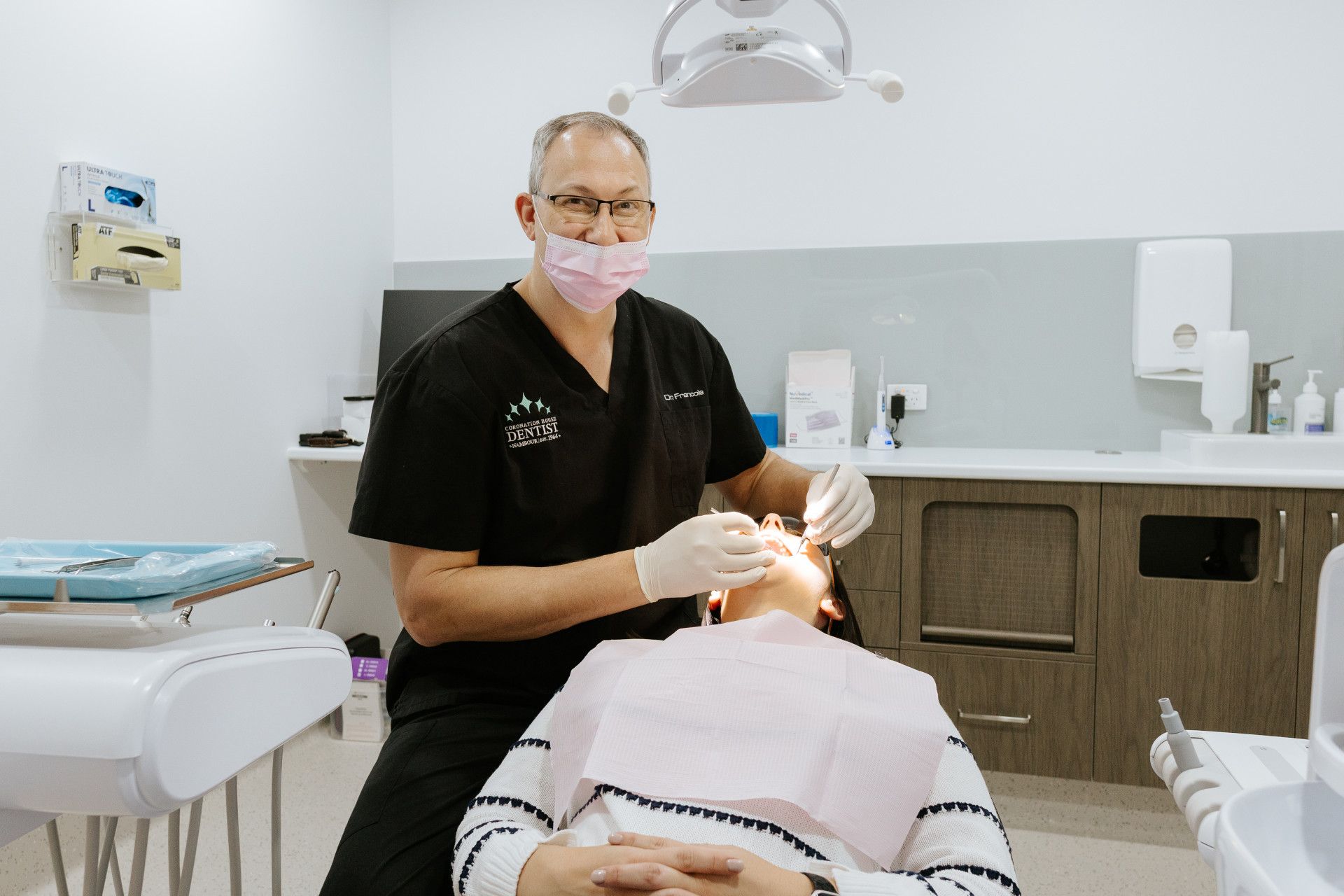 A Woman is Getting Her Teeth Examined by Two Female Dentists — Coronation House Dentist in Nambour, QLD