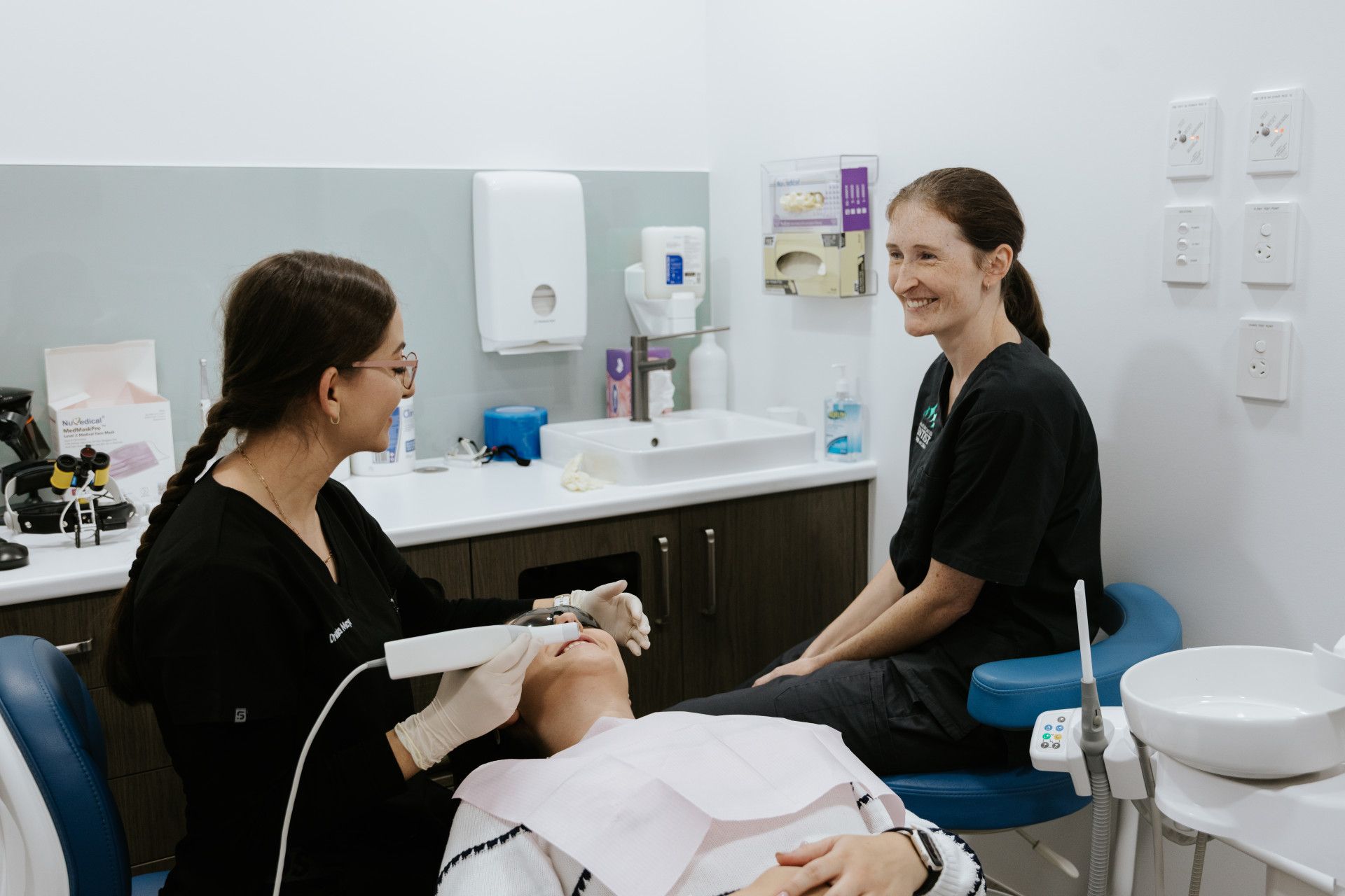 A Woman is Sitting in a Dental Chair While a Dentist Examines Her Teeth — Coronation House Dentist in Nambour, QLD