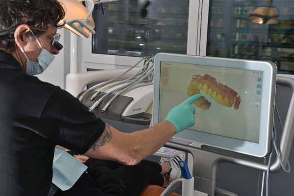 odontoiatra che analizza dentatura del paziente