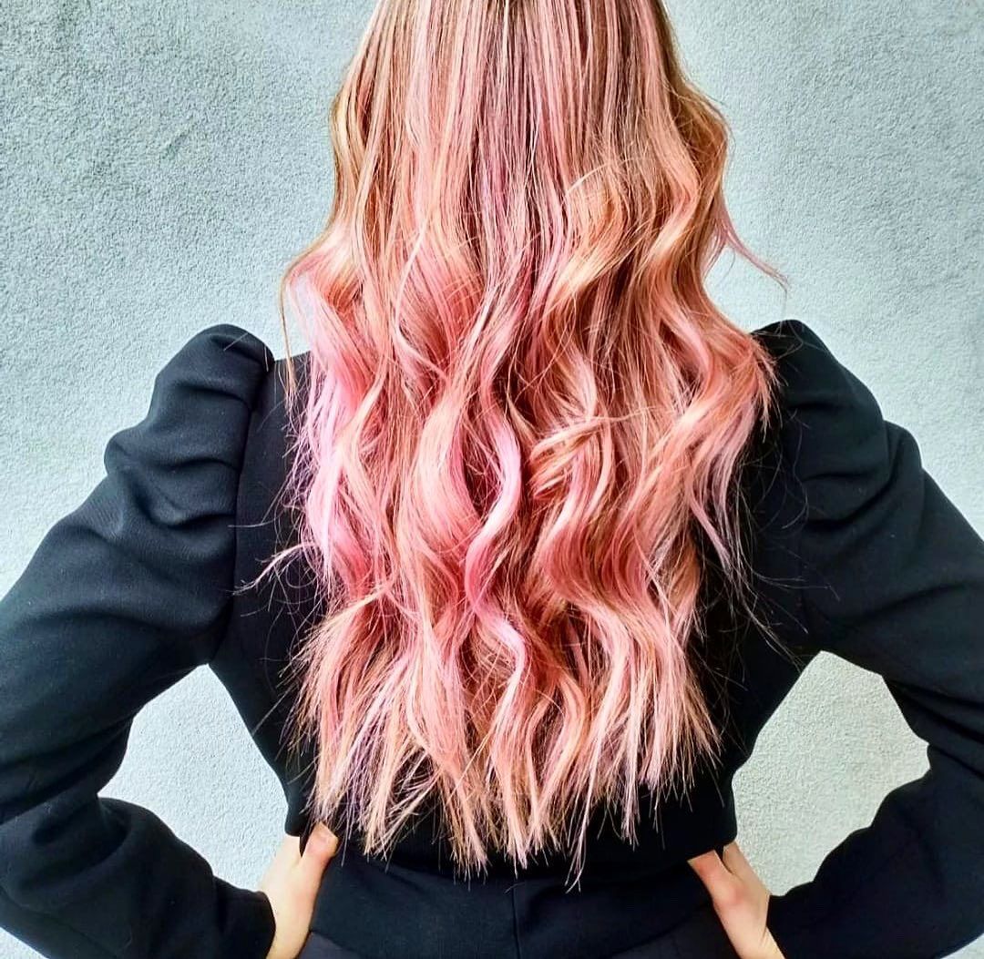 Una donna con i capelli rosa indossa una giacca nera