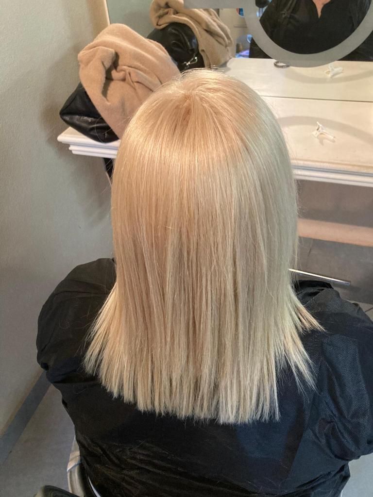 Una donna con i capelli biondi è seduta davanti allo specchio.