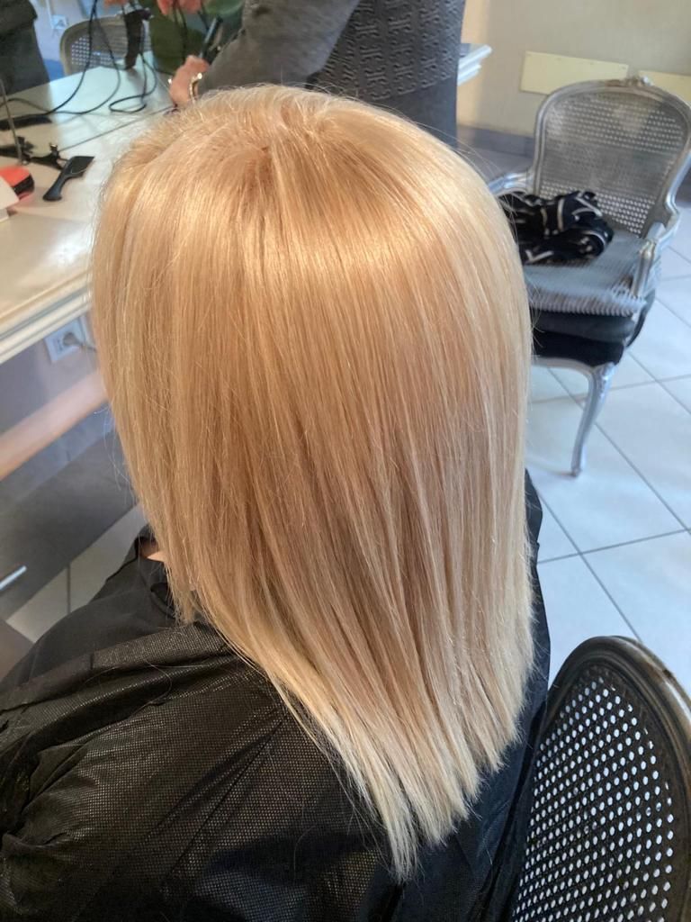 Una donna con i capelli biondi si sta tagliando i capelli in un salone.