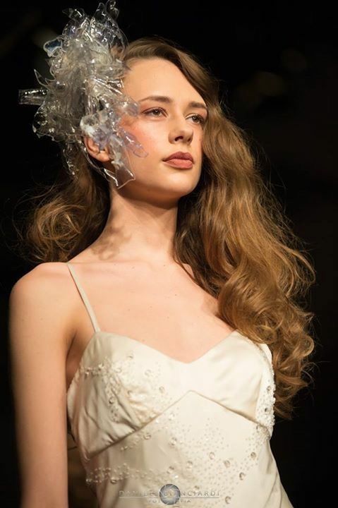 La donna indossa un abito bianco e un copricapo di plastica.