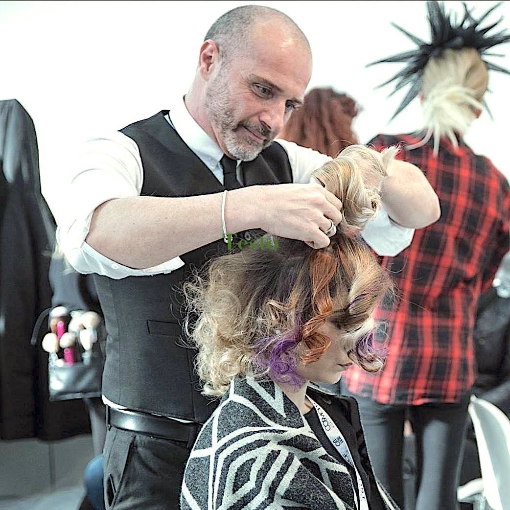 Un uomo sta spazzolando i capelli di una donna in un salone.