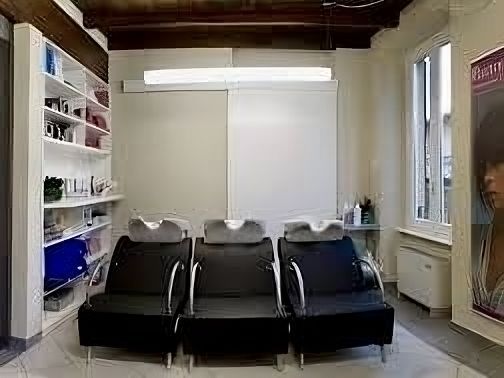 Un salone da parrucchiere con una fila di sedie e lavandini.