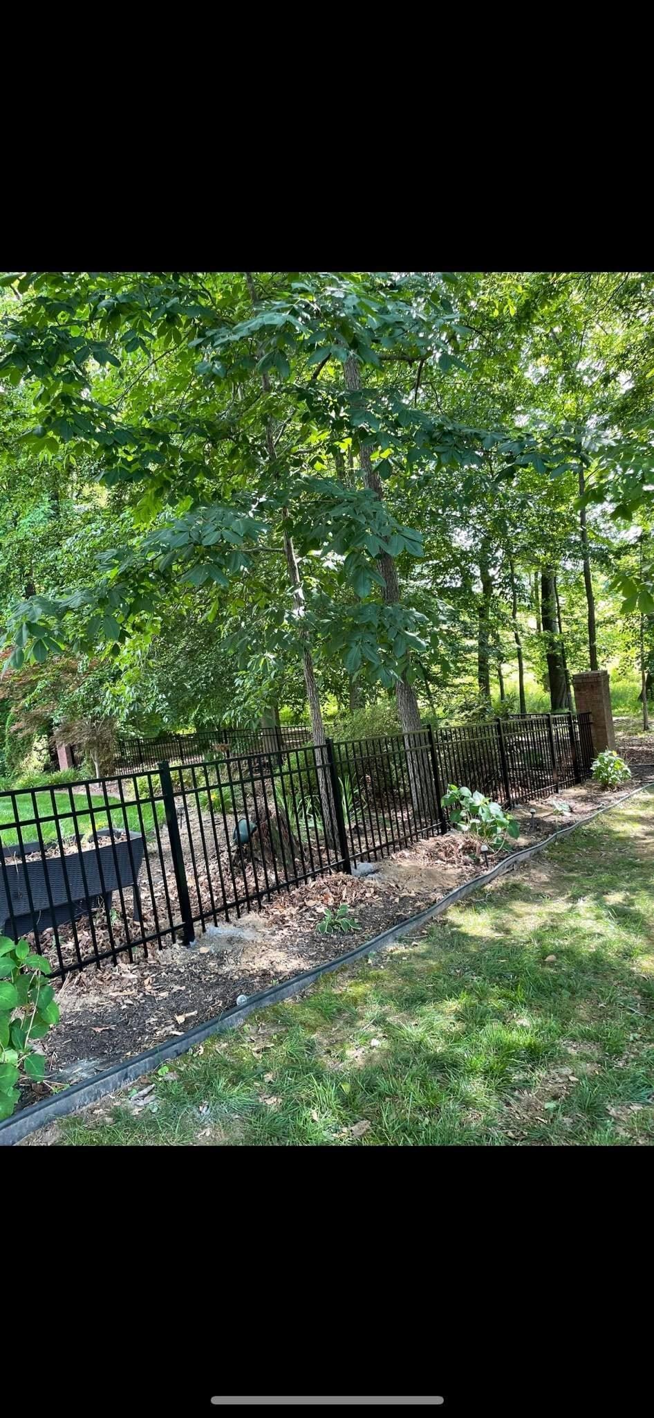There is a fence in the middle of the woods.