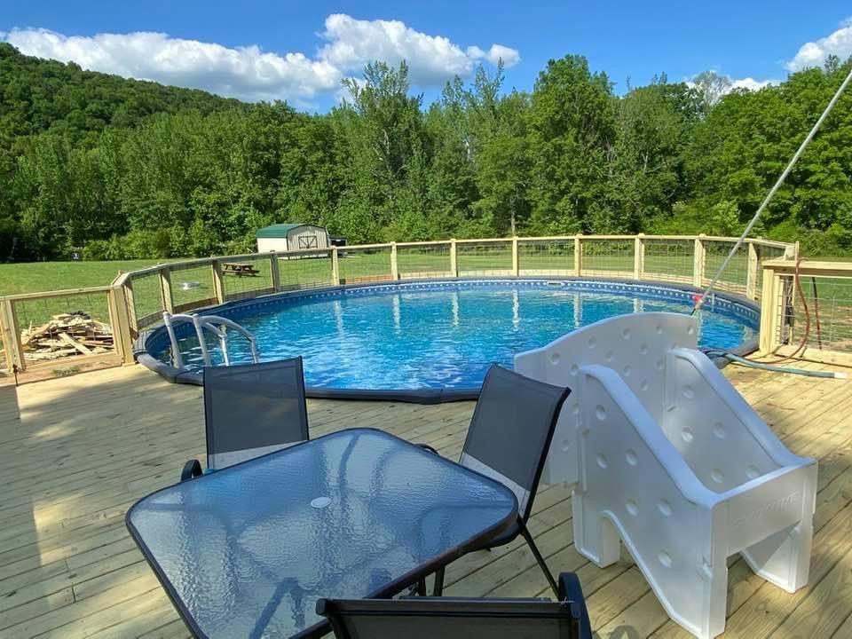 A large swimming pool with a table and chairs around it