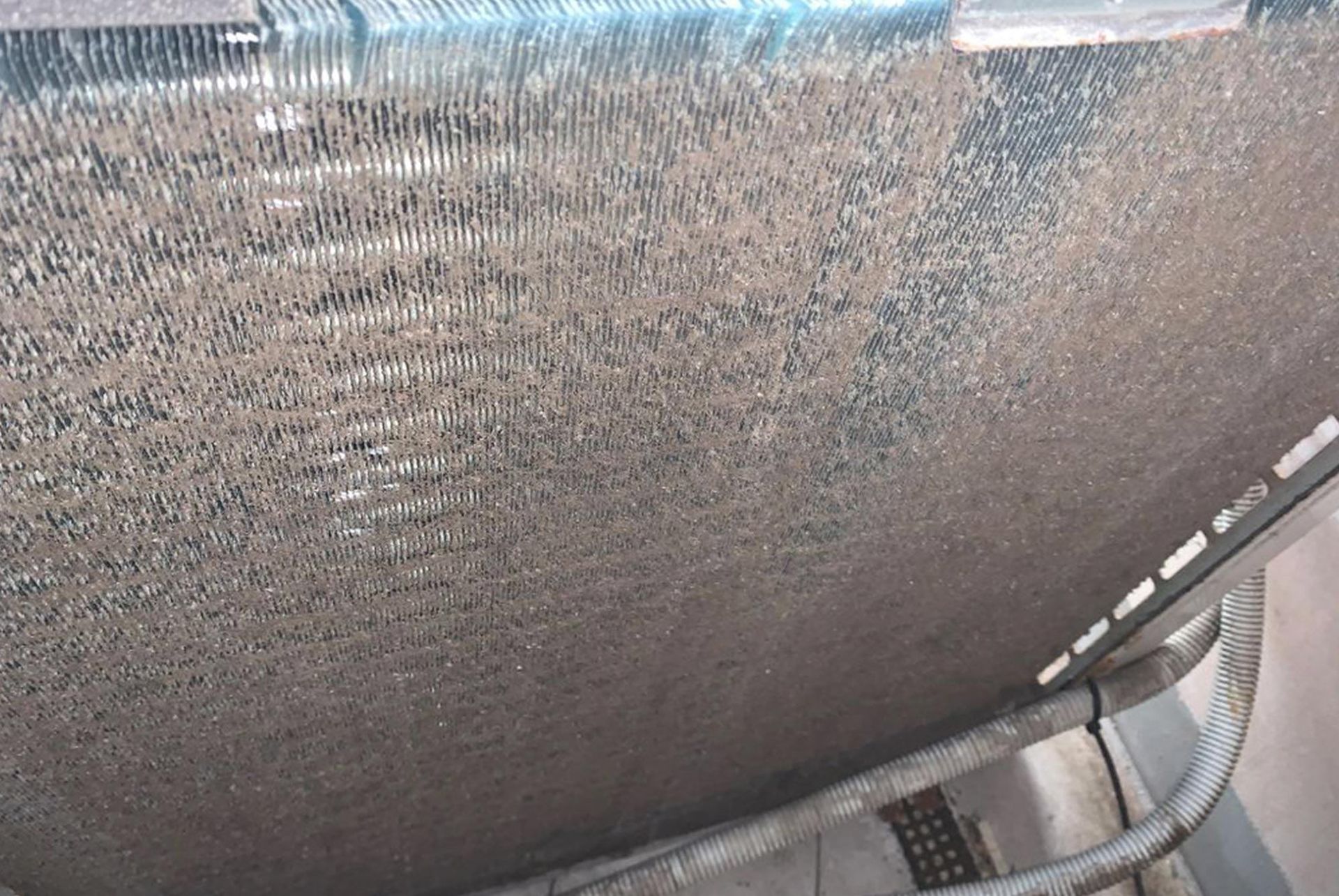 A close up of a dirty air conditioner coil.