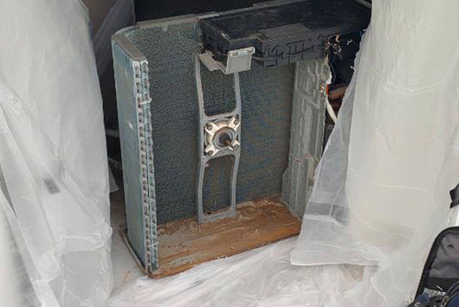 A computer case is sitting on top of a table covered in plastic.