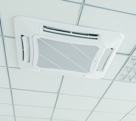 A white air conditioner is hanging from the ceiling