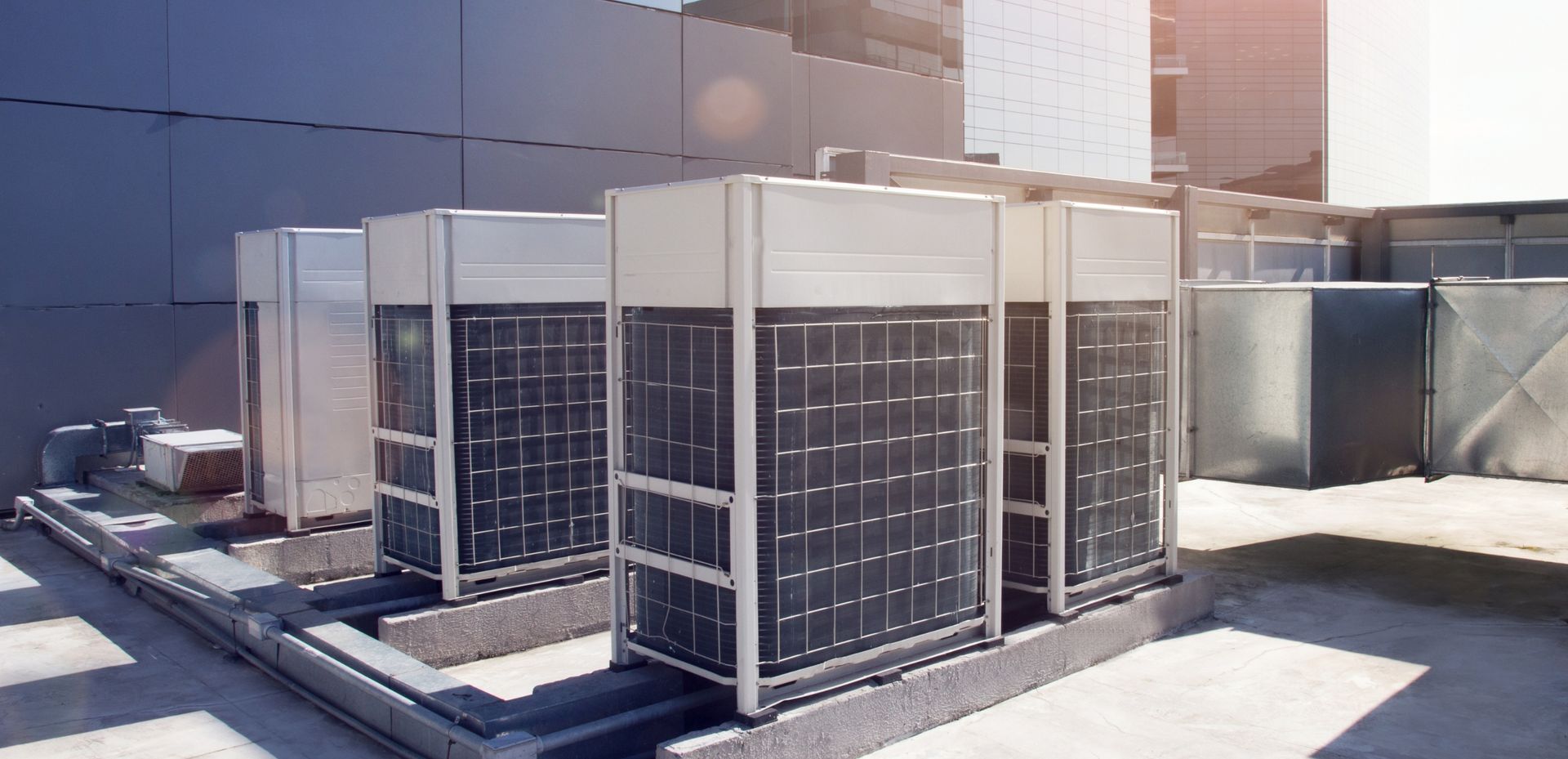 A row of air conditioners on the roof of a building.