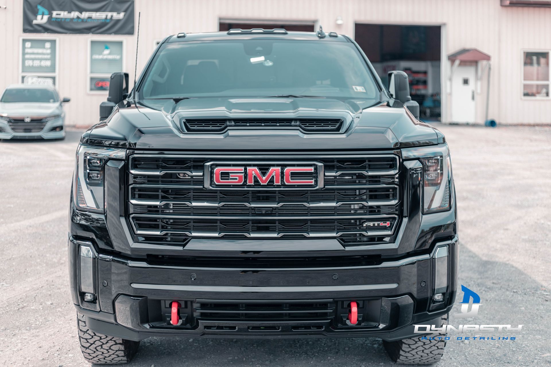 A black gmc truck is parked in a parking lot in front of a building.