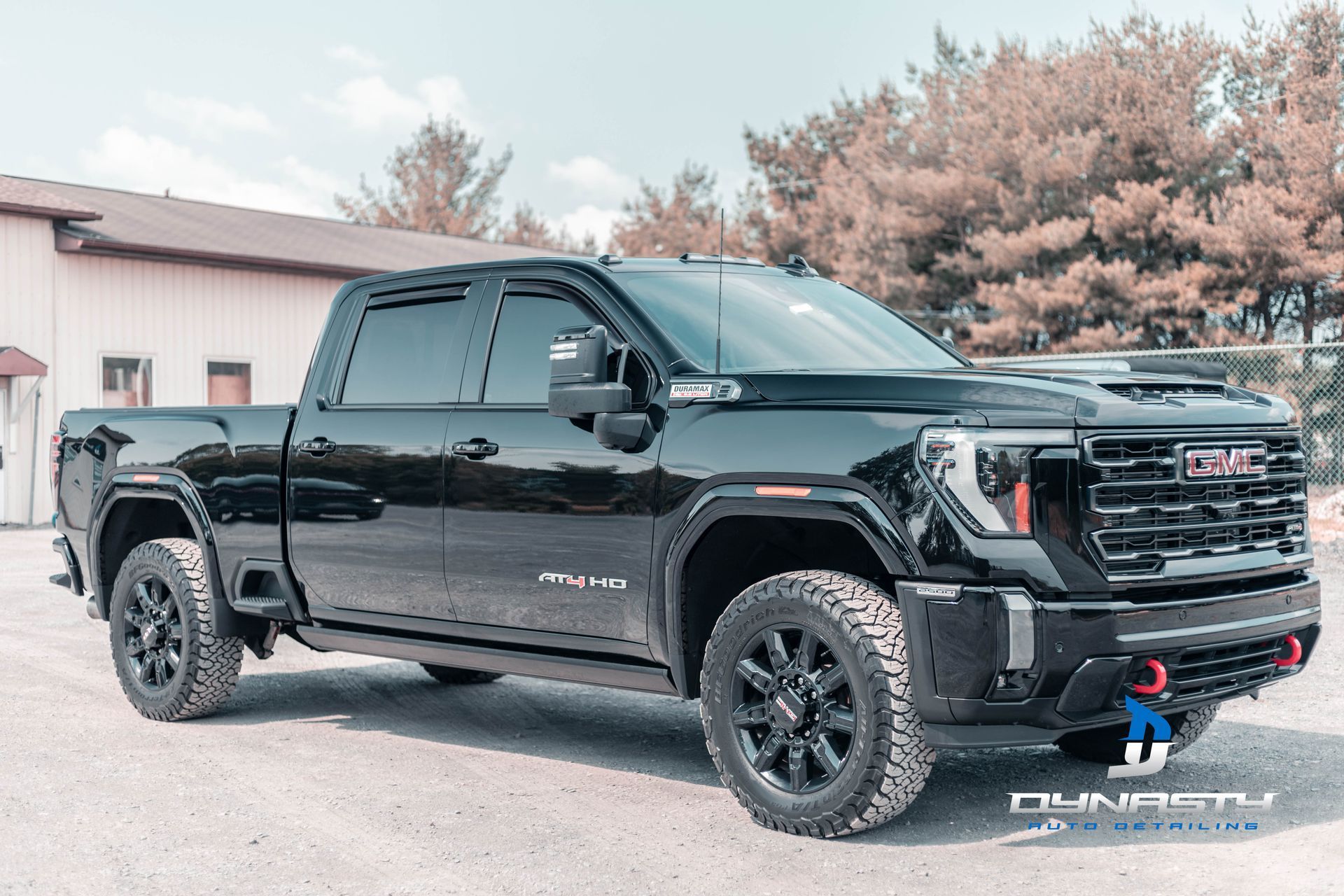 A black gmc truck is parked in front of a building.