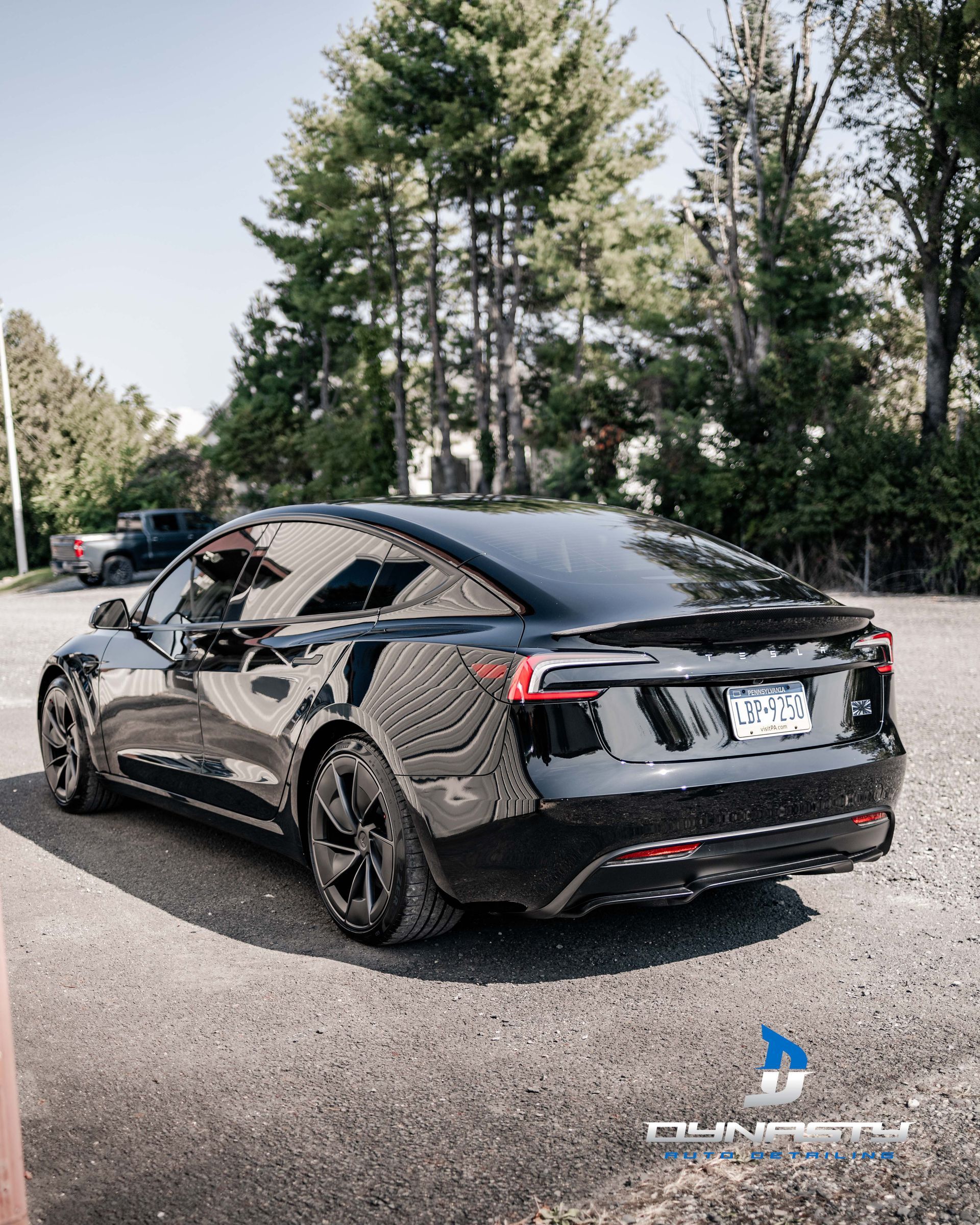 A black tesla model s is parked in a parking lot.