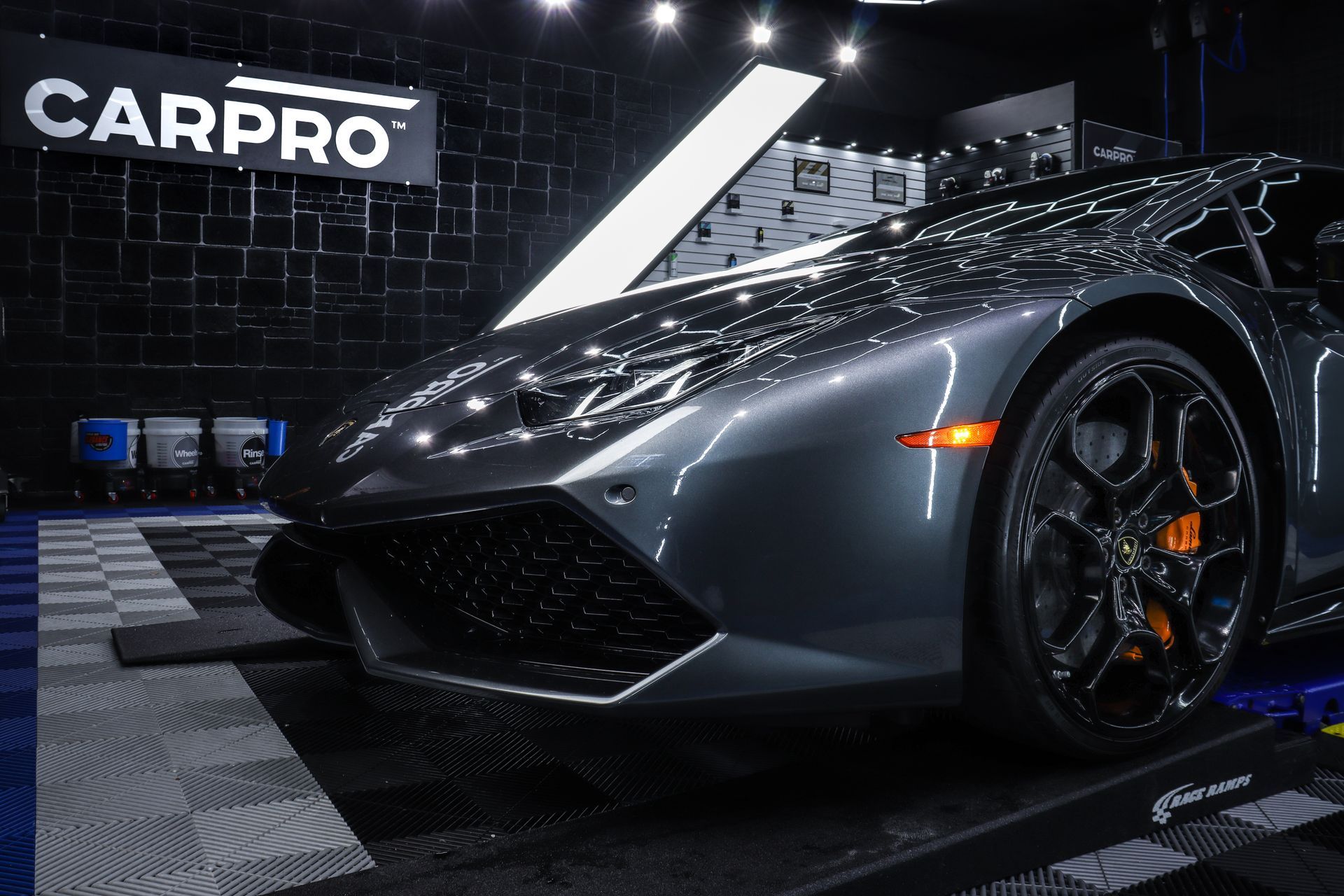 A gray lamborghini huracan is parked in a garage.