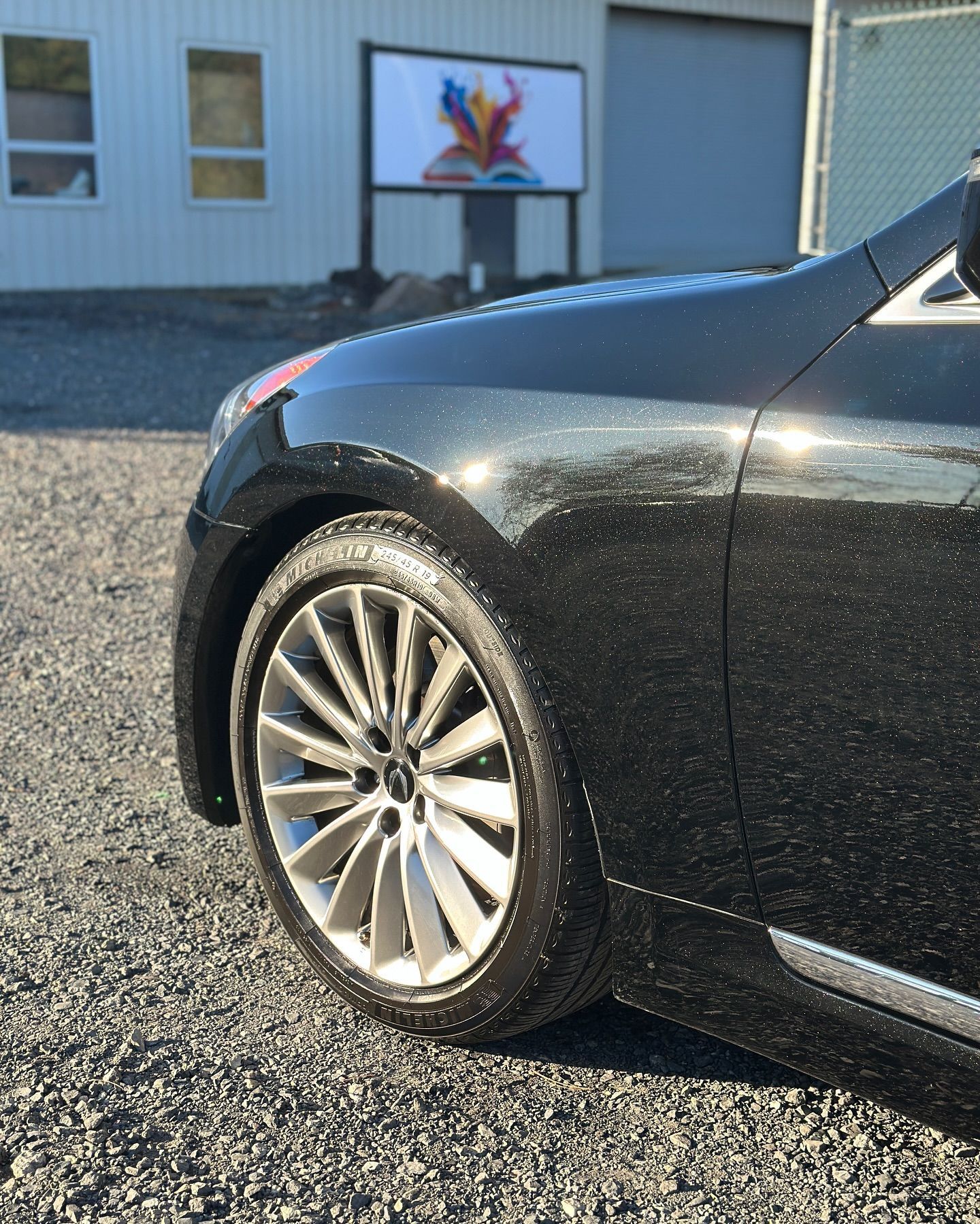 A black car is parked in front of a building