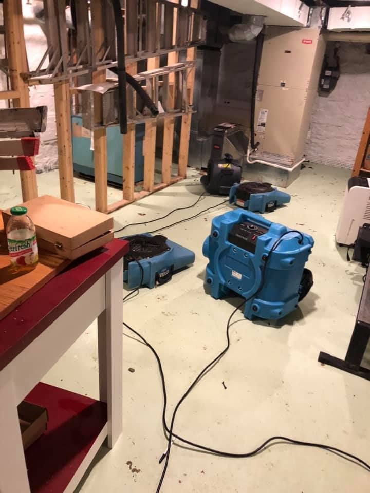 A narrow, cluttered hallway with light-colored walls