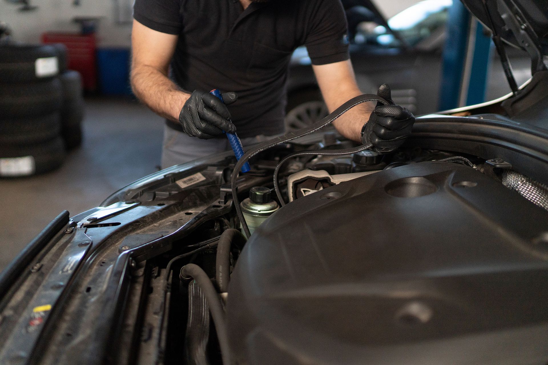 Mechanic working under the hood of a car in a garage