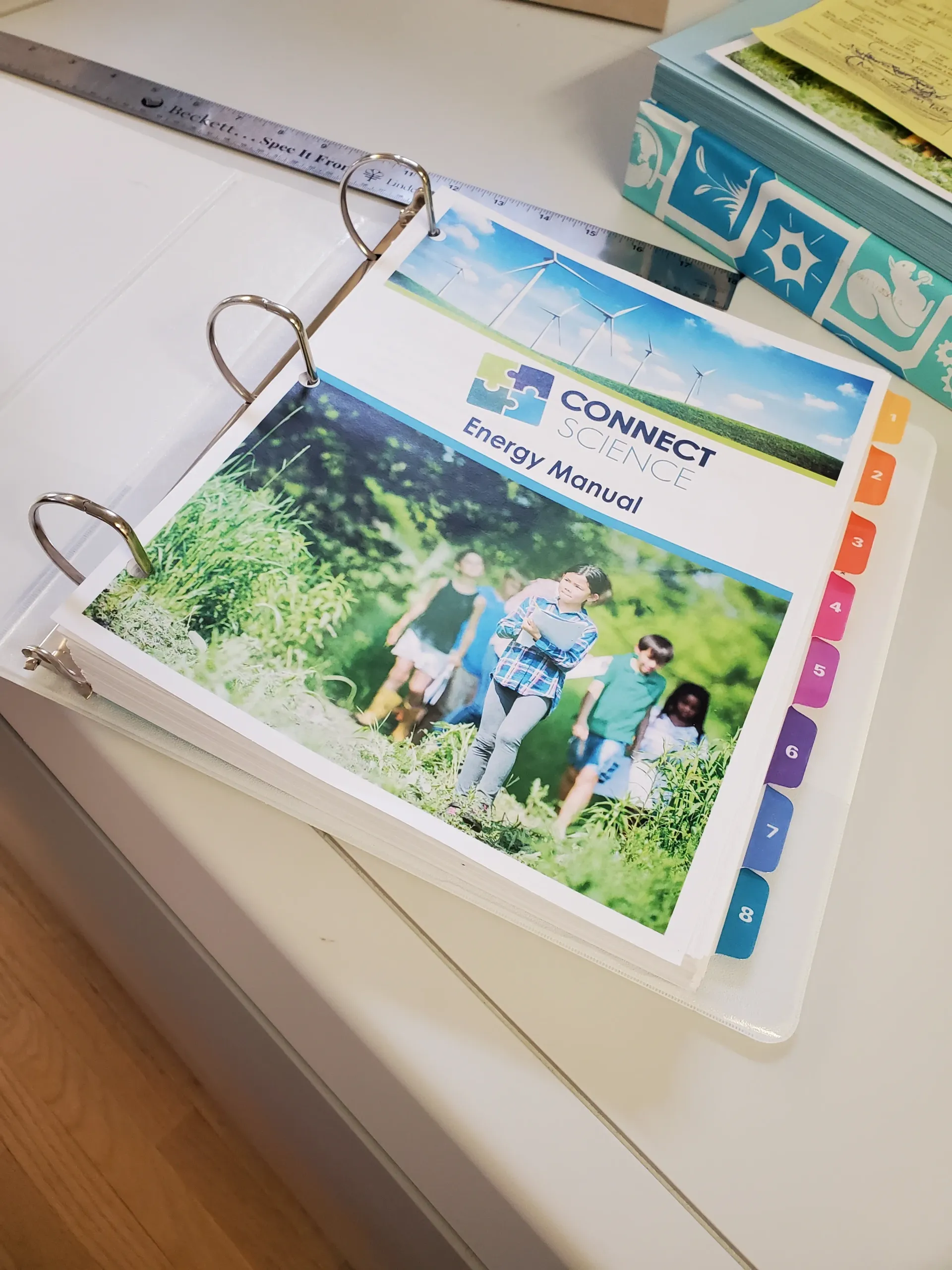 White binder open to a cover page titled 