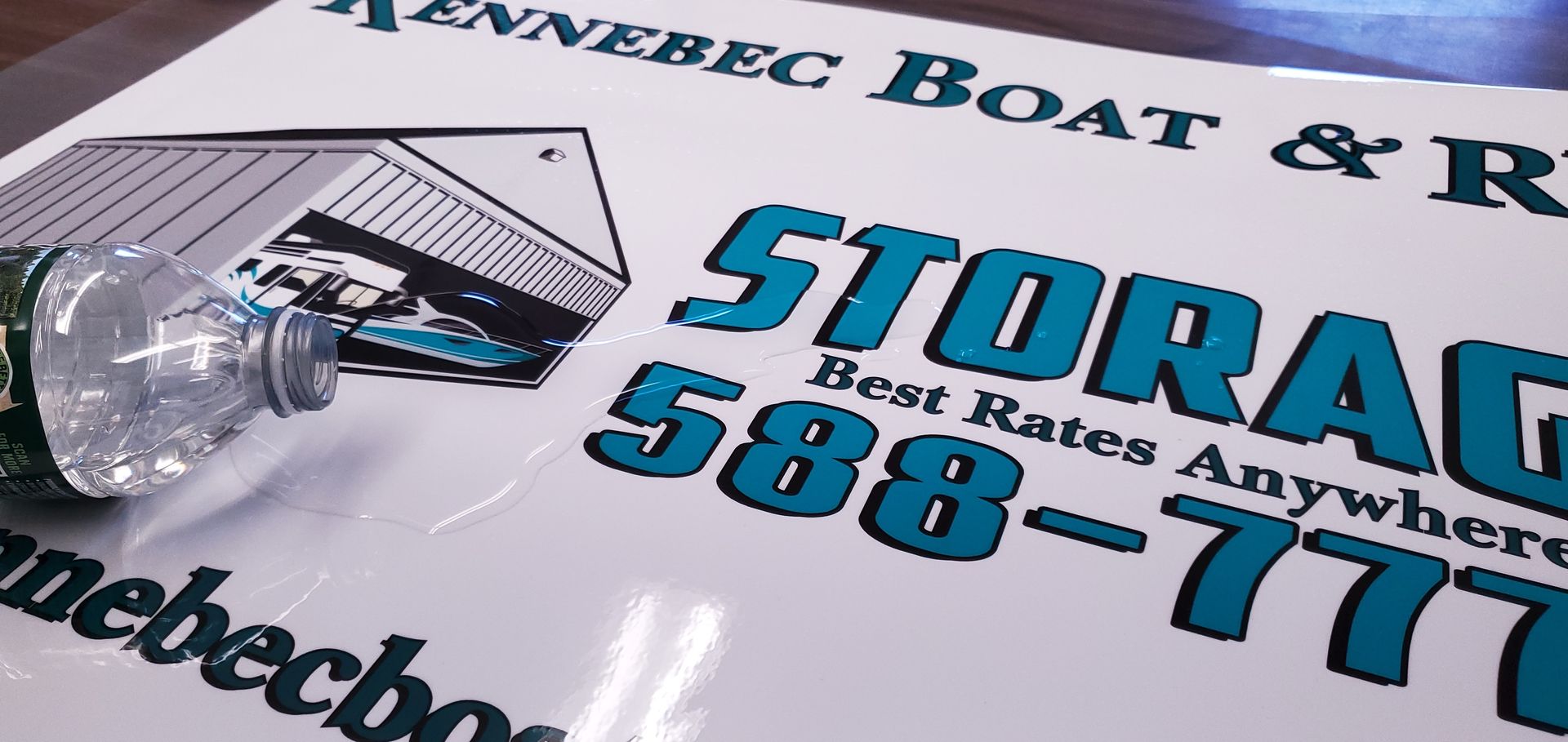 Sign for Kennebec Boat & RV Storage with water bottle; turquoise letters on white background.